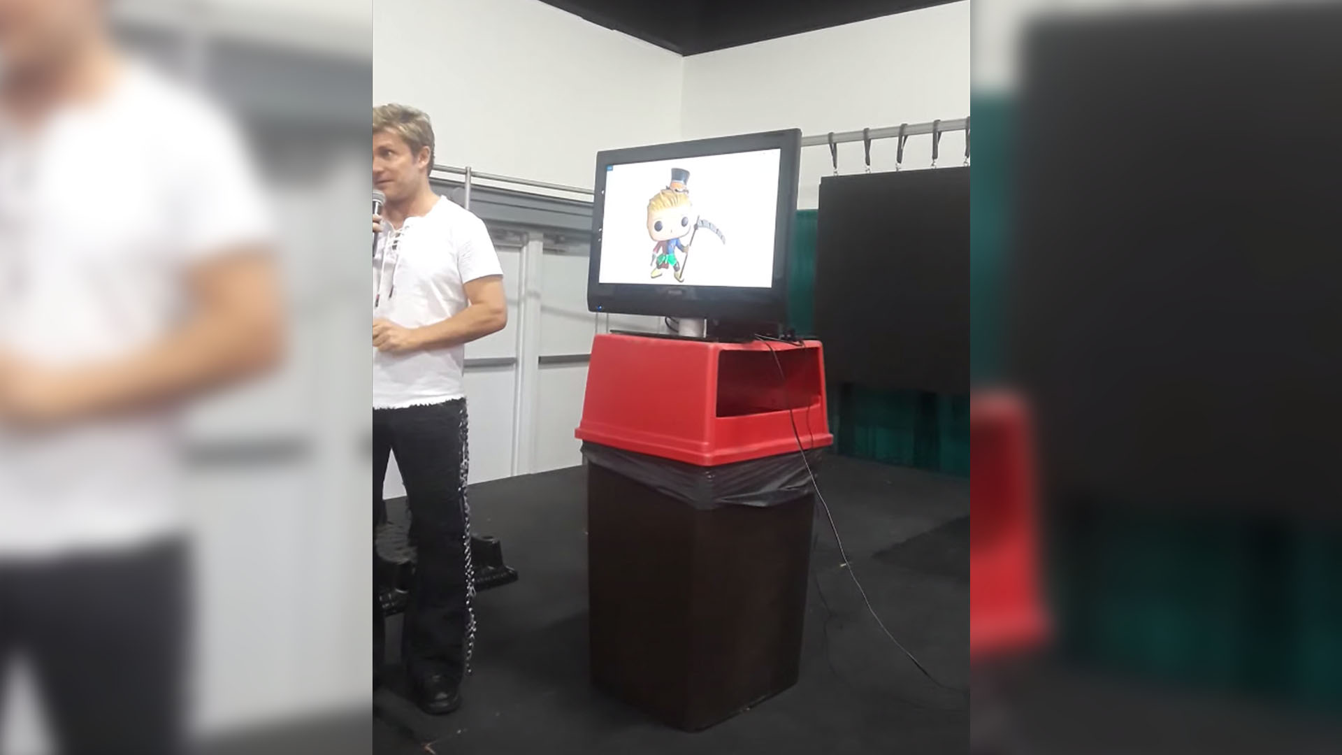 vicfigure Vic Mignonga standing next to a computer screen on a garbage